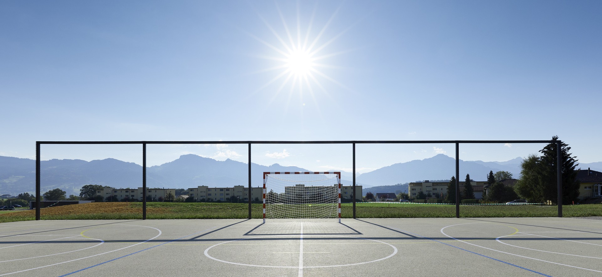 sports court with modern ball stop fence made of webnet
